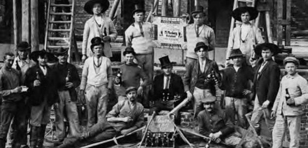 German Journeymen Posing With Tools And Beer. A Journeyman Wearing Traditional Guild Clothing